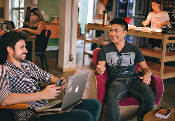 Dos profesionales colaborando en un espacio de coworking, firmando documentos digitales con Intellisign y optimizando flujos de trabajo